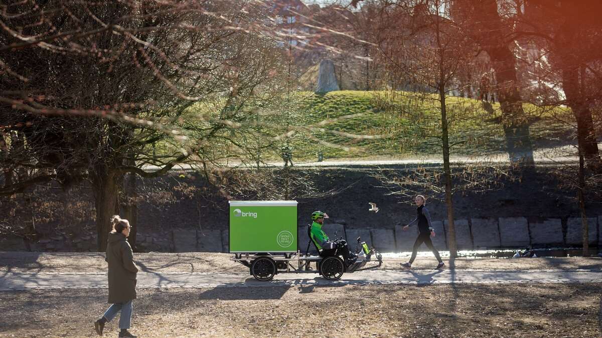 Bring employee riding an electric bike in a park