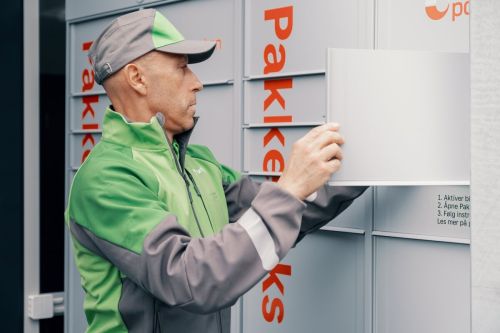 Bring driver puts a parcel in a parcel locker