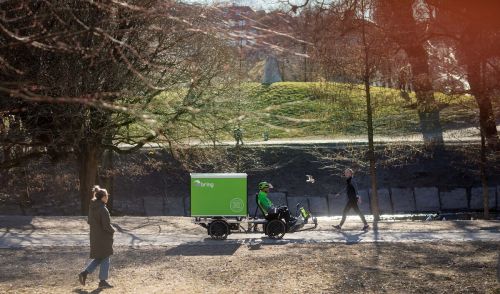 Bring employee riding an electric bike in a park